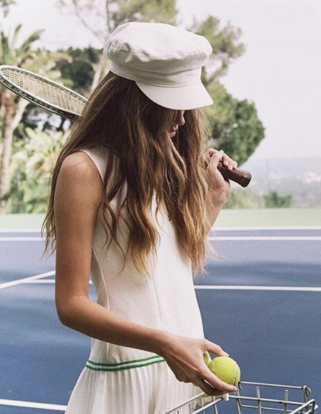 Model holding a racket and wearing a full on tennis outfit