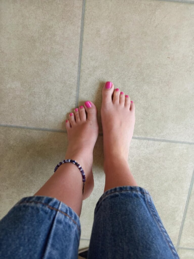 a woman with her feet in pink nail polish