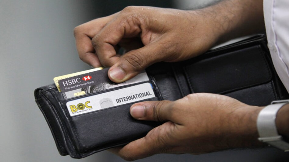 hombre abriendo billetera llena de tarjeta de crédito