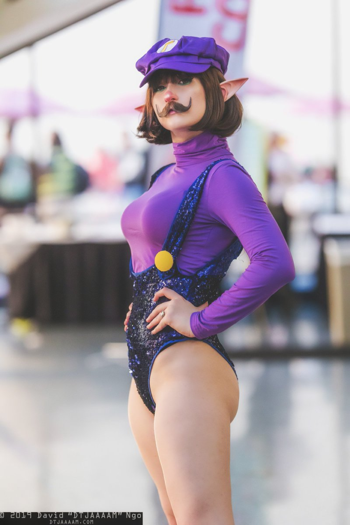 a woman wearing a purple mario cosplay