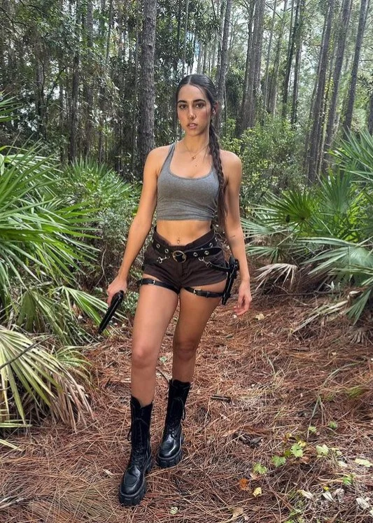 Izzy Green @izzygreen OnlyFans Sexy Foto eines Models im Wald mit einer Waffe