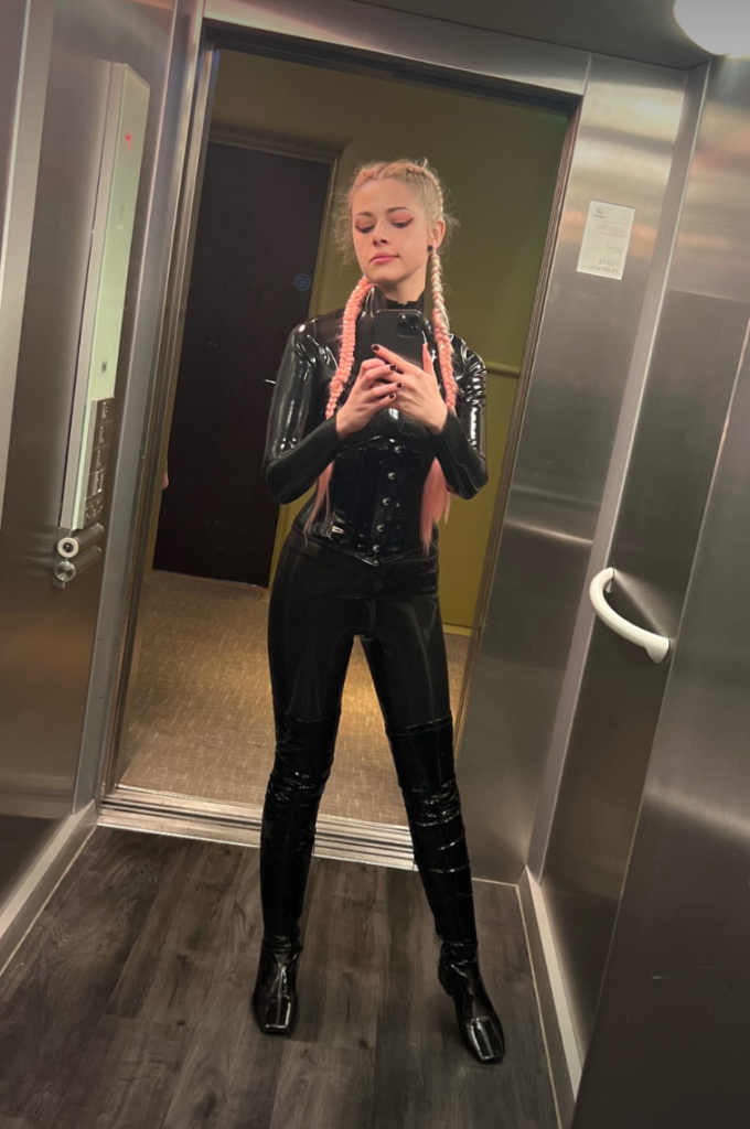 Mercy @mistressmercyxox Colchester OnlyFans hot model wearing tight black costume in the elevator showing her curvy body.