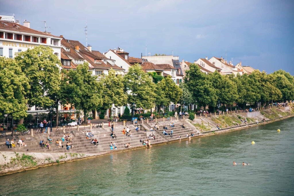 Rhine River with several people sitting at the bank perfect spot for meeting Basel women