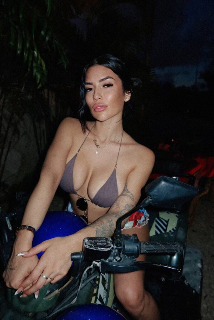 Luchi Del Mar OnlyFans big tits model wearing sexy two piece bikini sitting on a bike