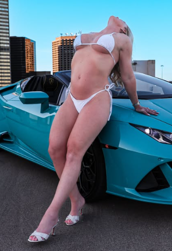 Sweet Vickie posing in front of a green Porsche in a white bikini